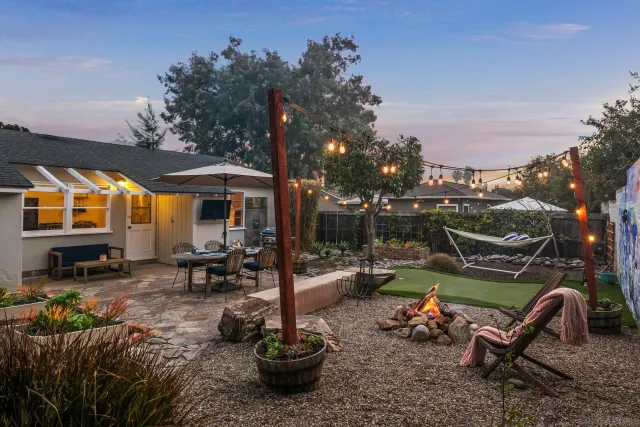 a view of a house with backyard water fountain and sitting area