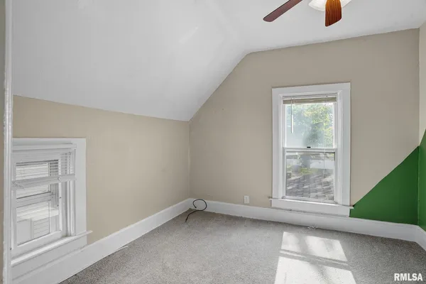 a view of a room with a ceiling fan and entryway