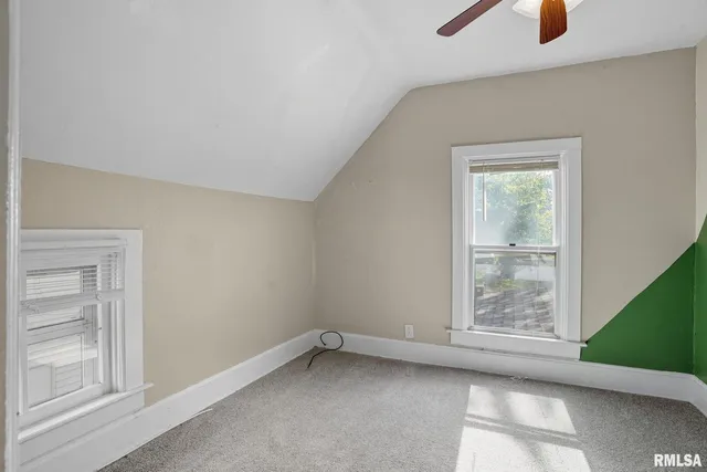 a view of a room with a ceiling fan and entryway