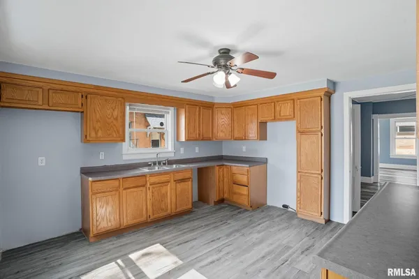 a kitchen with stainless steel appliances granite countertop a sink and dishwasher a refrigerator with wooden floor