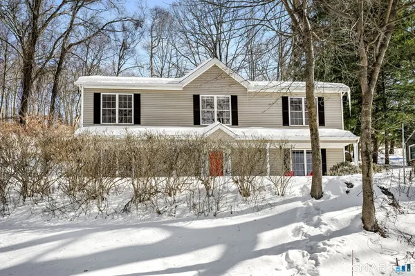 a view of a house with a yard covered in snow