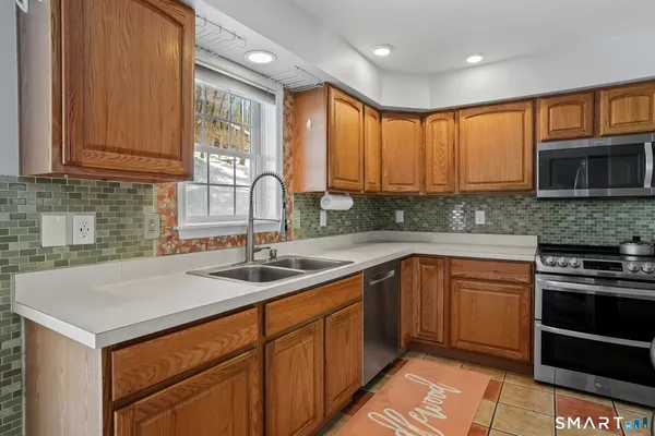 a kitchen with stainless steel appliances granite countertop a sink stove and microwave