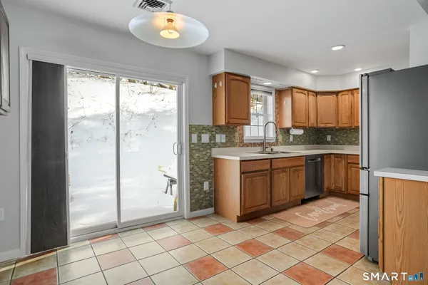 a kitchen with a sink a counter top space cabinets and stainless steel appliances