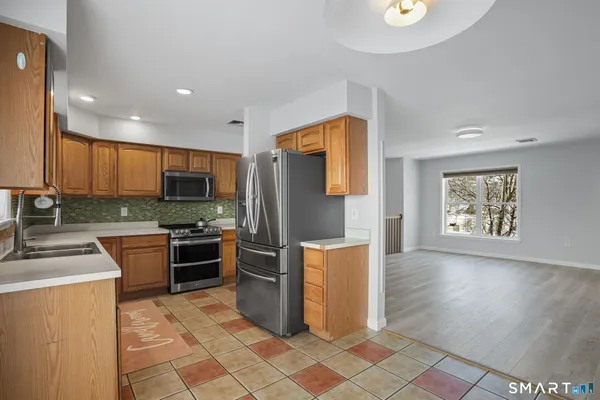 a kitchen with stainless steel appliances kitchen island granite countertop a refrigerator stove and sink