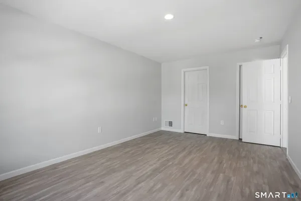 a view of an empty room with wooden floor