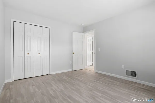 a view of an empty room with wooden floor