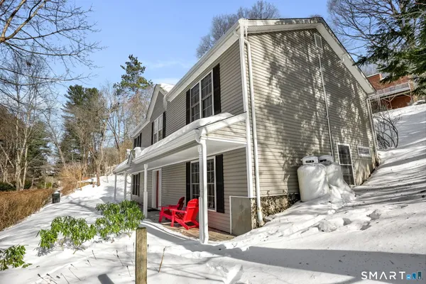 a view of a house with a small yard and potted plants