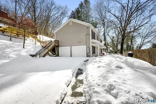 a view of large house with a yard covered in snow