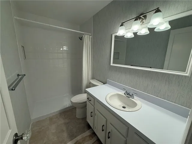 a bathroom with a sink a toilet and a mirror