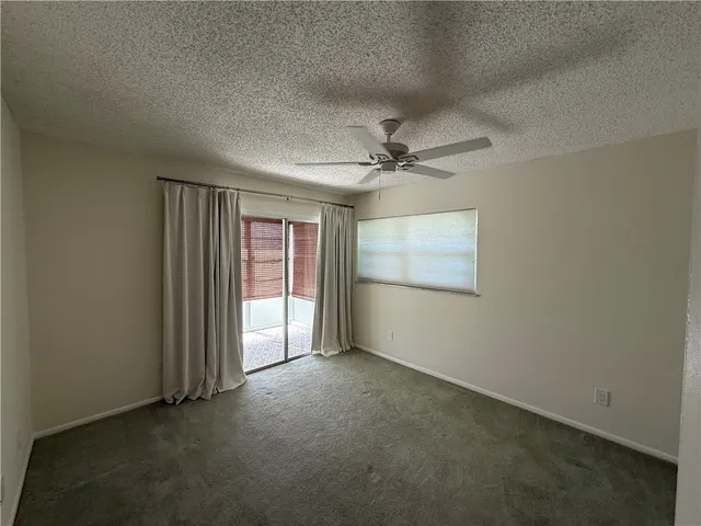 an empty room with chandelier fan