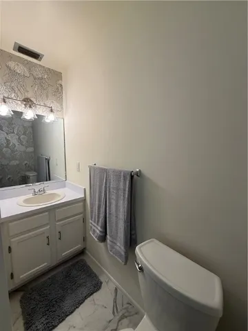 a bathroom with a toilet a sink and mirror