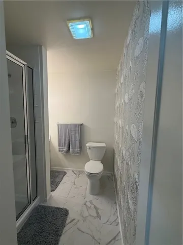 a bathroom with a toilet and a shower