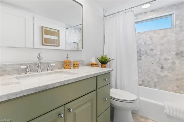 a bathroom with a granite countertop sink a toilet a mirror a vanity and shower