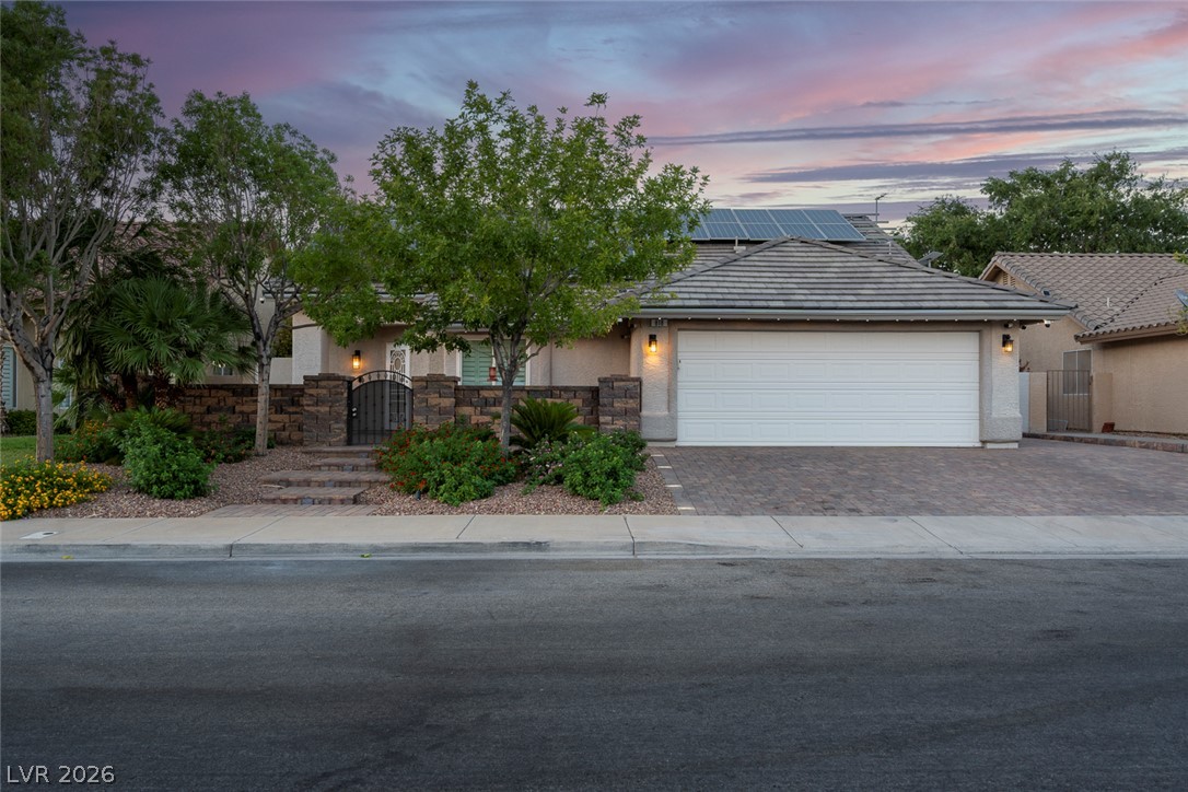 818 Manor Shores Road Henderson, NV 89002 - Photo 1 of 35 A welcoming stone-clad entryway with an ornate gate leads to this charming home with a paved driveway.