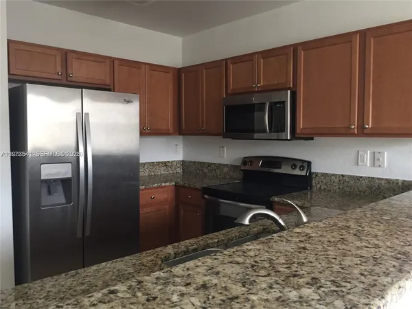 a kitchen with a refrigerator stove and cabinets