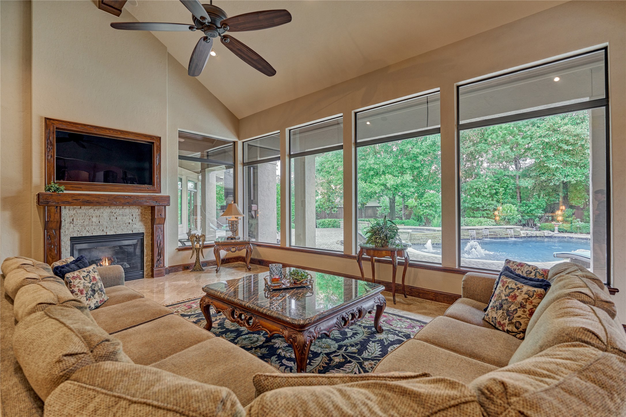 24803 Pearl Crest Lane Spring, TX 77389 - Photo 12 of 50 Grand Den features a vaulted ceiling and fireplace with wall-to-wall windows of the resort-style backyard.