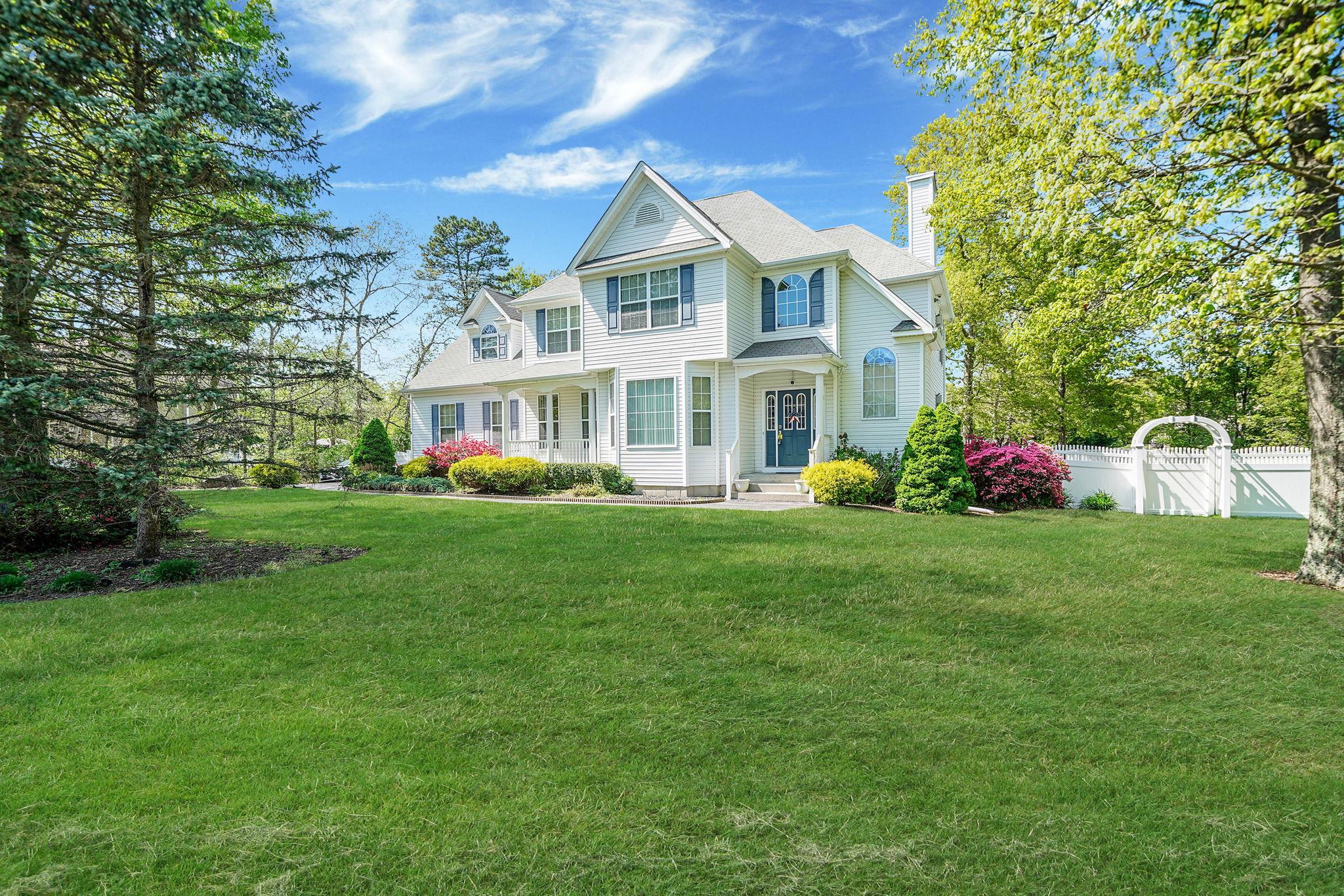 1 Gingham Court Ridge, NY 11961 - Photo 1 of 1 a front view of a house with garden and trees