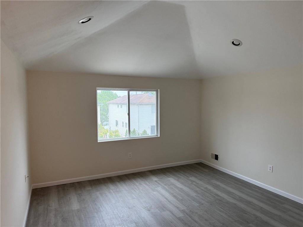 7 Georgetown Lane Brooklyn, NY 11234 - Photo 15 of 32 an empty room with wooden floor and windows