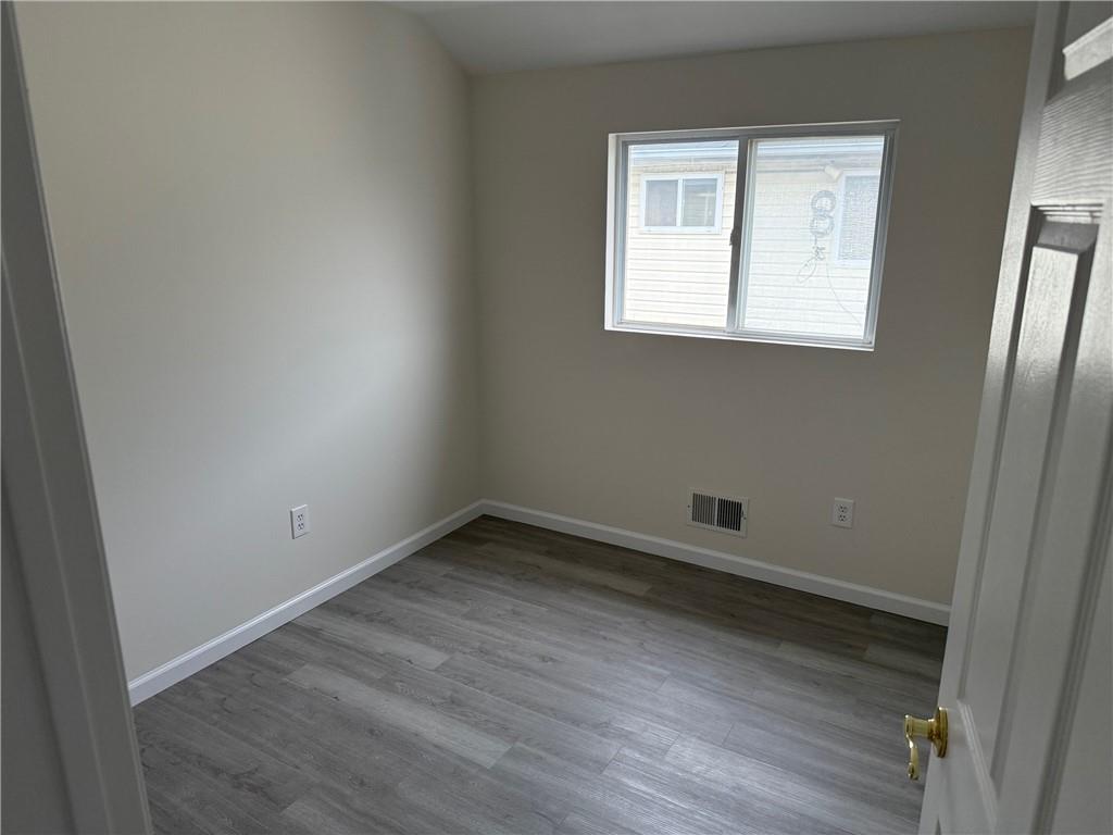 7 Georgetown Lane Brooklyn, NY 11234 - Photo 16 of 32 an empty room with wooden floor and windows