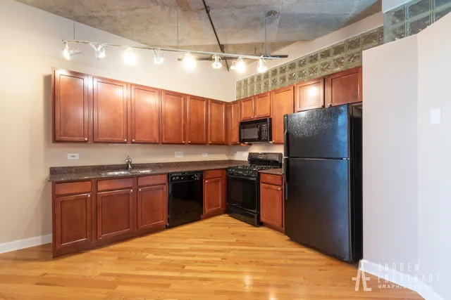 a kitchen with stainless steel appliances granite countertop a refrigerator a sink and a stove