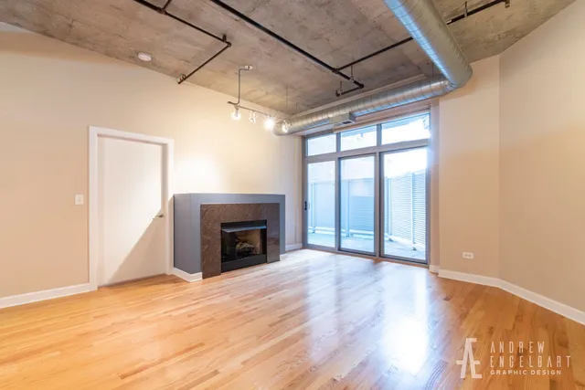 a view of empty room with wooden floor and fireplace
