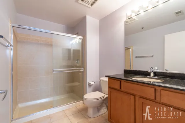 a bathroom with a granite countertop sink toilet and shower