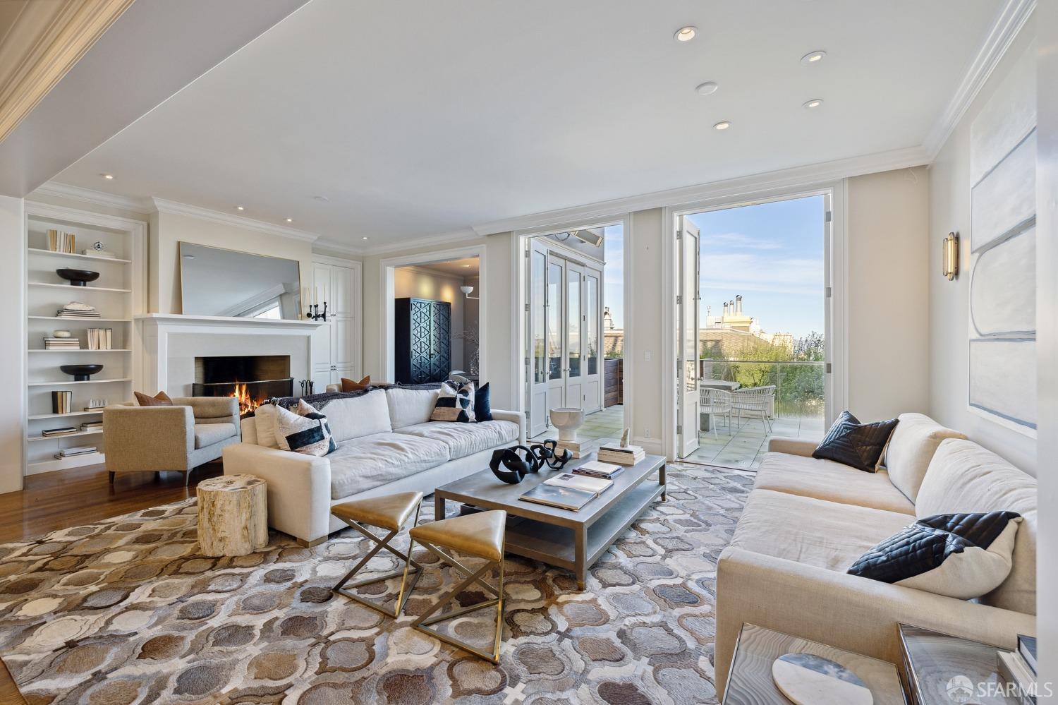 a living room with furniture a fireplace and a floor to ceiling window