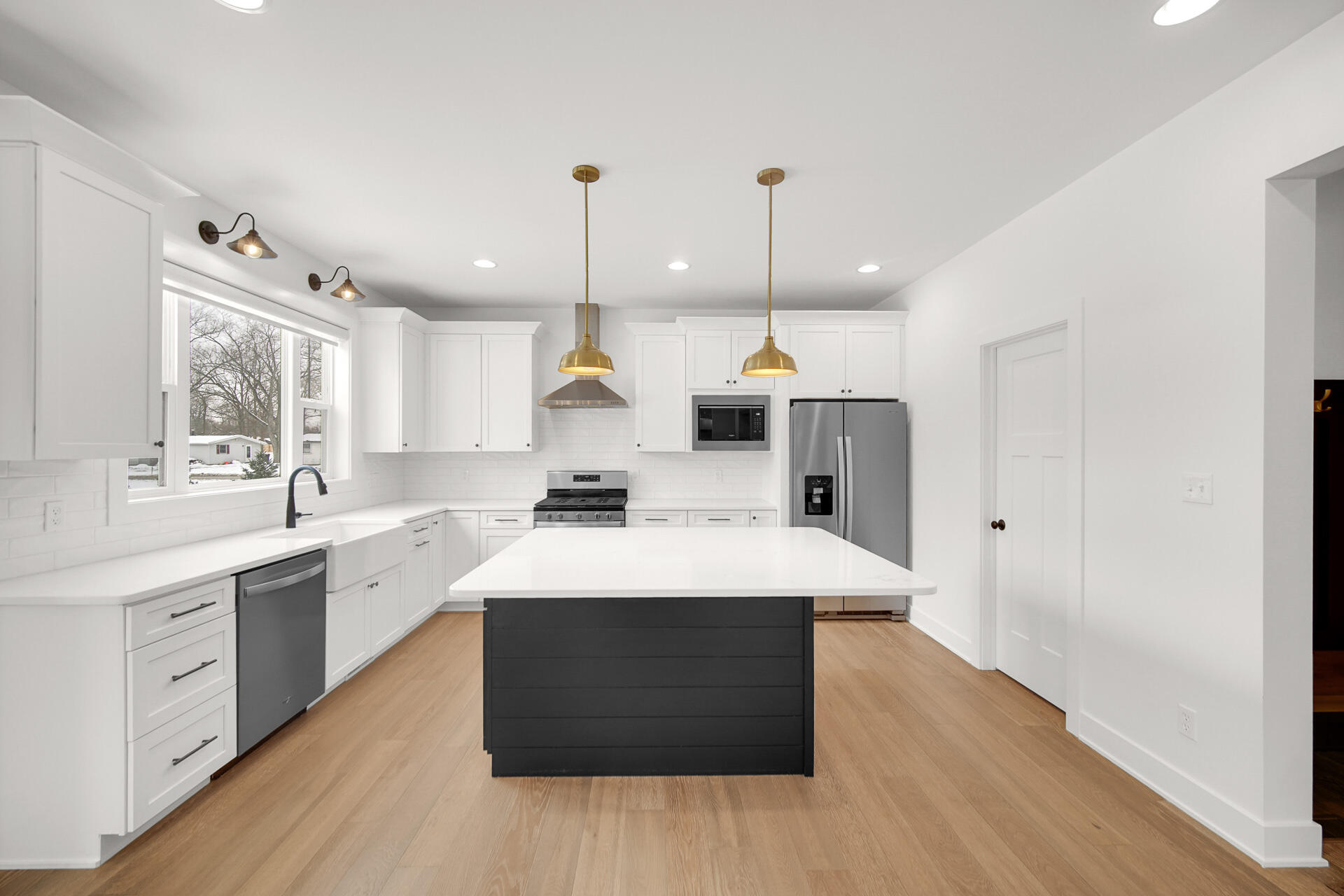 1079 Kleven Lane Crown Point, IN 46307 - Photo 14 of 37 a large kitchen with a stove a sink a refrigerator and a wooden floor