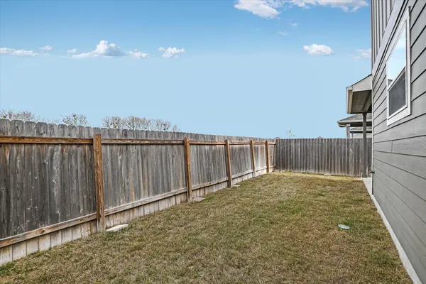 a view of backyard with wooden fence