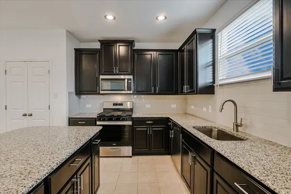 a kitchen with stainless steel appliances granite countertop a sink stove and cabinets