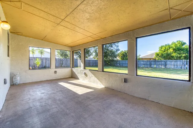 a view of an empty room with a fireplace and windows