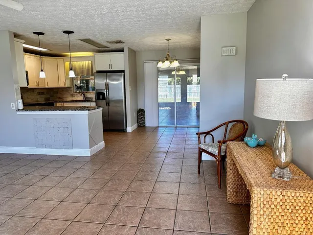 a large kitchen with granite countertop a stove a sink a refrigerator and a dining table