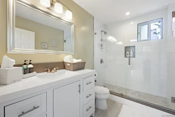 a bathroom with a sink a toilet and shower