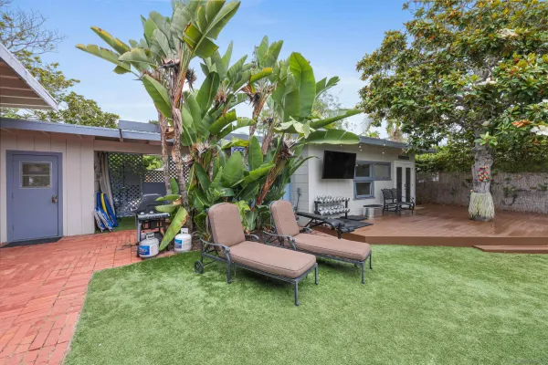 a view of a patio with couches table and chairs potted plants and palm tree