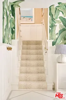 a view of a hallway with painting on the wall and a window
