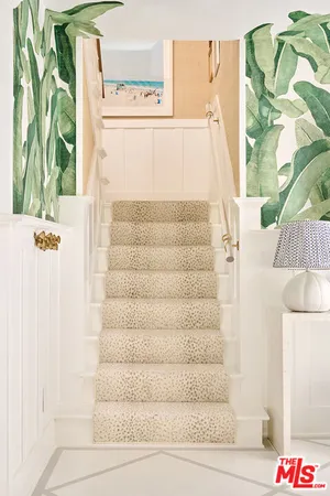 a view of a hallway with painting on the wall and a window