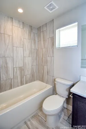 a white toilet sitting next to a bath tub