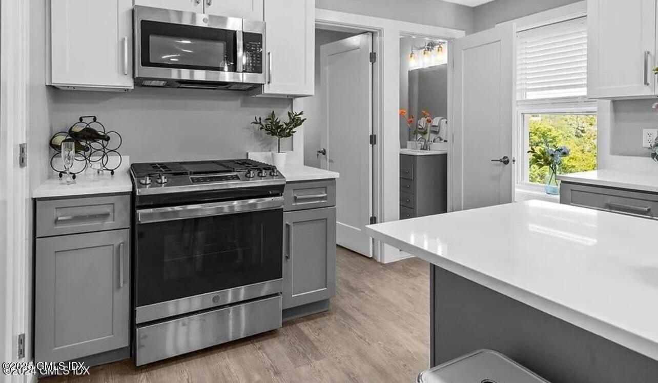 168 North Water Street, Unit 2L Greenwich, CT 06830 - Photo 3 of 11 a kitchen with stainless steel appliances a stove a microwave and cabinets