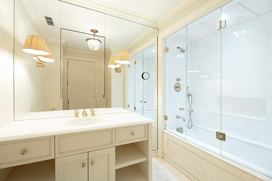 4 East 72nd Street, Unit 3/4B Manhattan, NY 10021 - Photo 13 of 15 a bathroom with a bathtub shower sink vanity and mirror