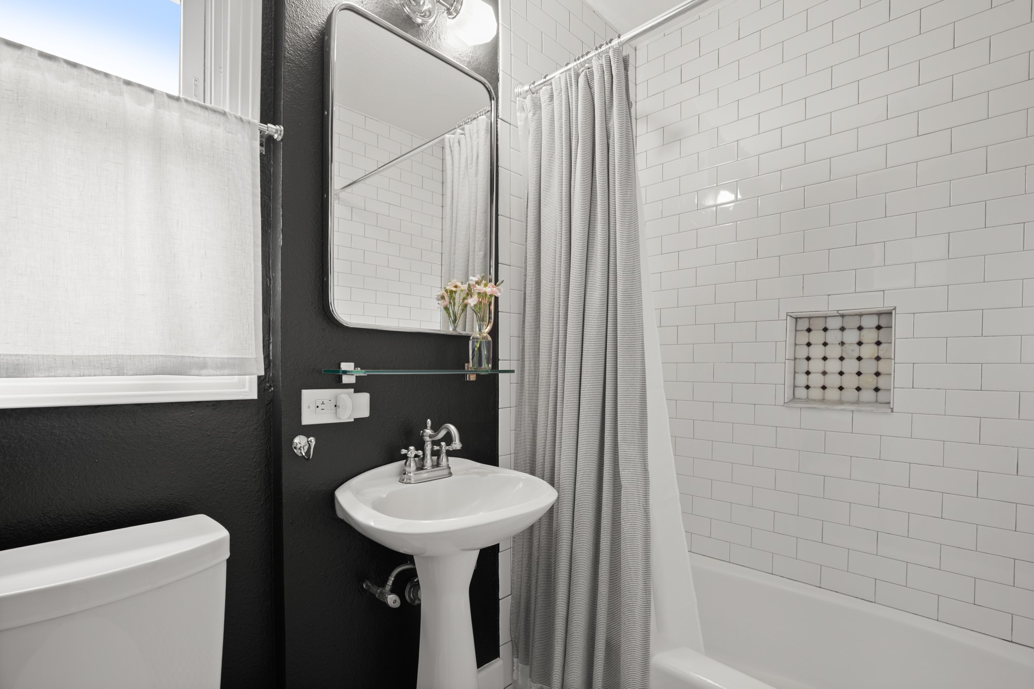 2010 Alegria Road Austin, TX 78757 - Photo 23 of 35 Bathroom featuring a pedestal sink, subway tile shower surround, integrated shower niche with decorative tile, and a rectangular mirror