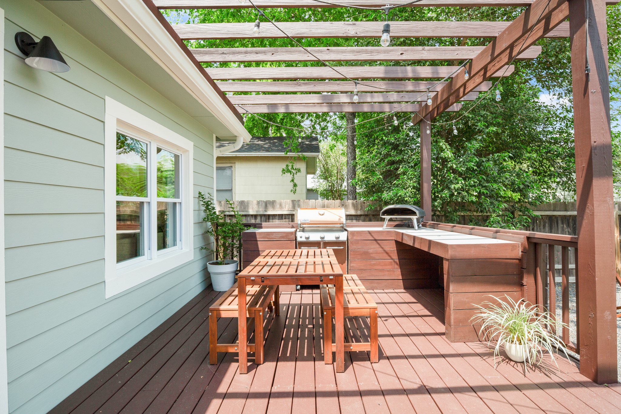 2010 Alegria Road Austin, TX 78757 - Photo 25 of 35 Expansive wood-finish deck featuring a pergola, built-in outdoor kitchen with grill, and an additional built-in countertop space