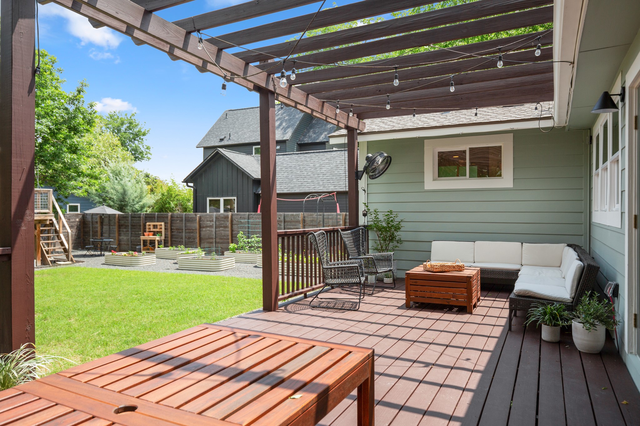 2010 Alegria Road Austin, TX 78757 - Photo 29 of 35 Spacious outdoor living area featuring a pergola-covered wood-finish deck, light green siding, a manicured lawn, and raised garden beds