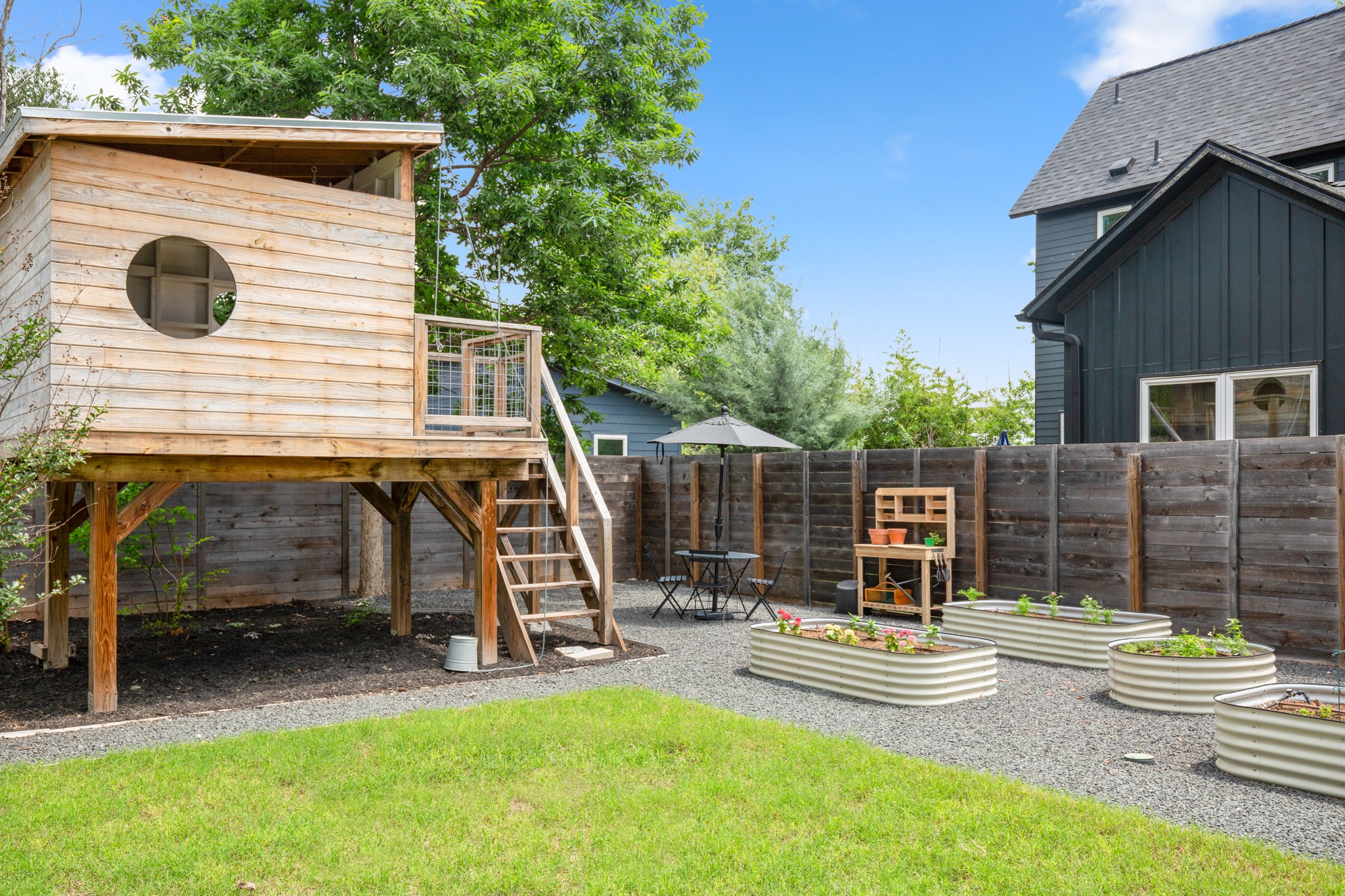 2010 Alegria Road Austin, TX 78757 - Photo 34 of 35 Expansive backyard featuring a custom wooden play structure with elevated platform and stairs