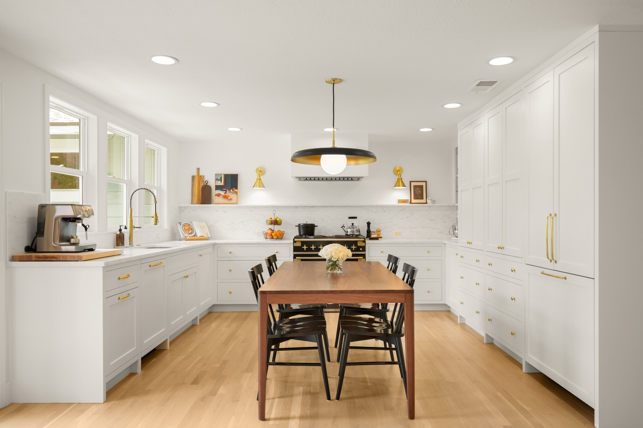 2010 Alegria Road Austin, TX 78757 - Photo 5 of 35 Bright kitchen featuring extensive white custom cabinetry with gold-finish hardware, light wood-finish flooring, and white marble countertops with a matching backsplash