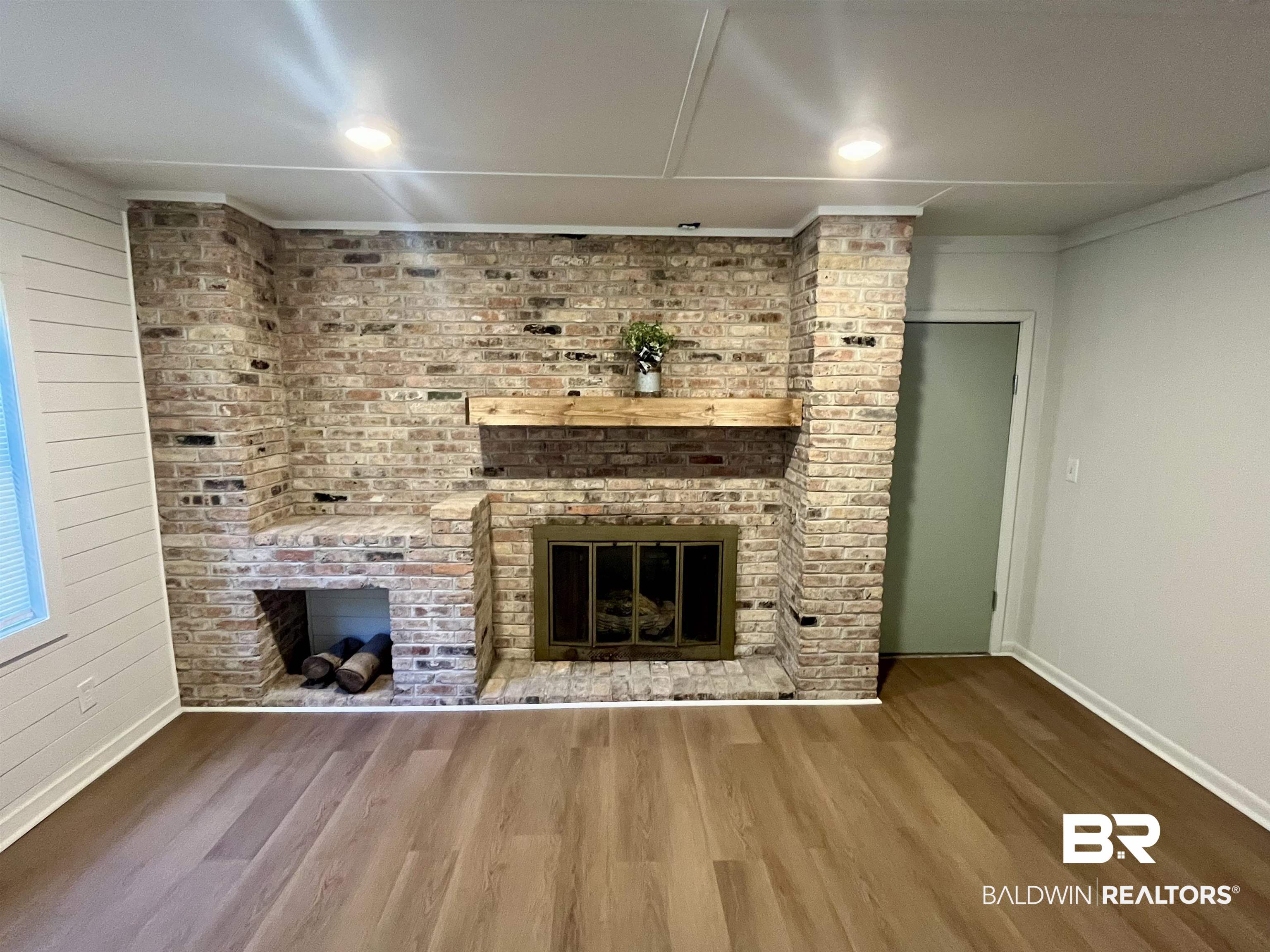3105 Bryant Road Mobile, AL 36605 - Photo 17 of 39 Brick fireplace featuring a wood mantel and integrated wood storage