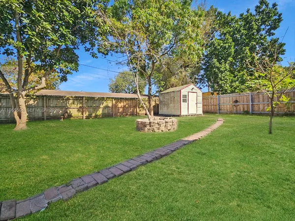 a view of a house with backyard and a tree