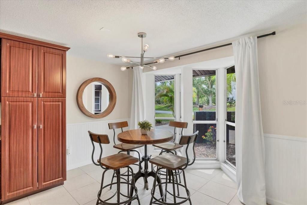 4696 Pompano Street Placida, FL 33946 - Photo 11 of 23 a dining room with furniture a chandelier and wooden floor