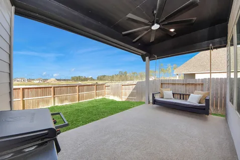 a view of a patio with a table chairs and a floor to ceiling window