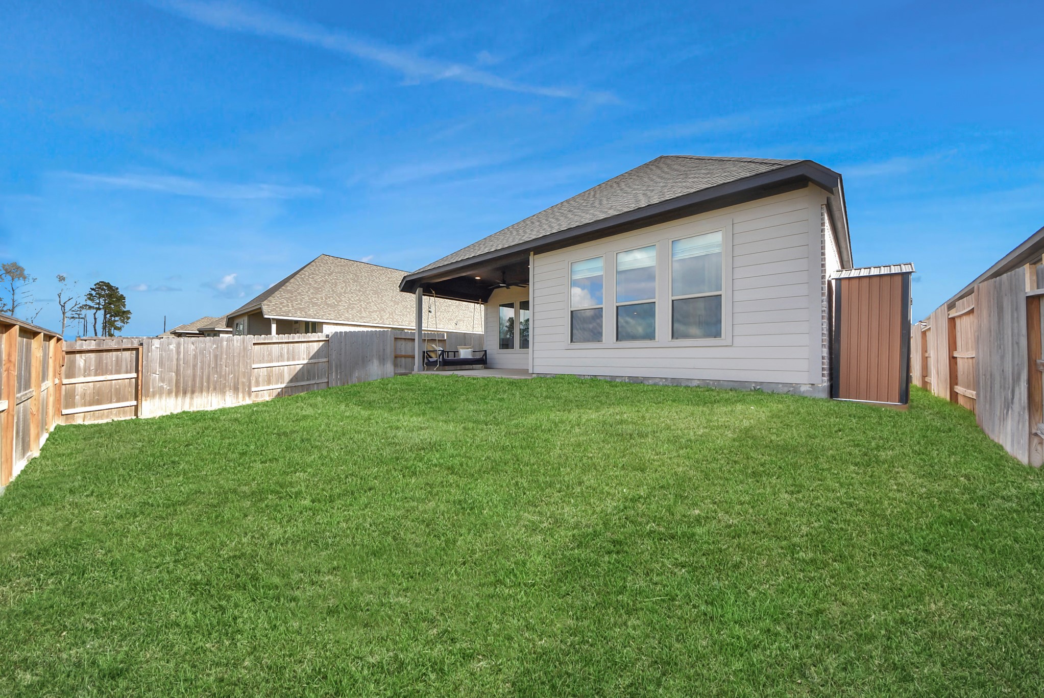 42546 Summer Crst Road Magnolia, TX 77354 - Photo 24 of 27 The rear of this modern single-story Perry Home showcases a beautifully maintained backyard and a covered patio designed for year-round outdoor enjoyment—perfect for relaxing, entertaining, or family activities.