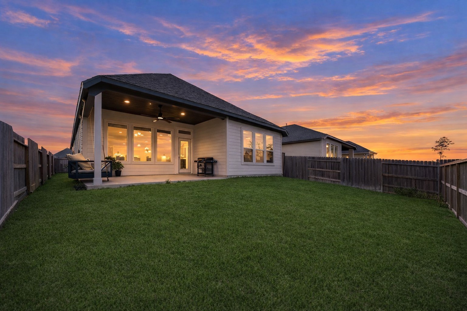 42546 Summer Crst Road Magnolia, TX 77354 - Photo 25 of 27 Step into your private retreat—a spacious backyard with a lush, manicured lawn and a covered patio perfect for alfresco dining or quiet mornings. Framed by large windows and a wooden fence, this serene outdoor space invites both relaxation and gatherings with friends and family.